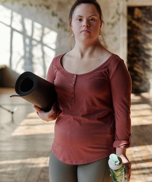 Bright, open living room with a yoga mat on the floor, ready for exercise.