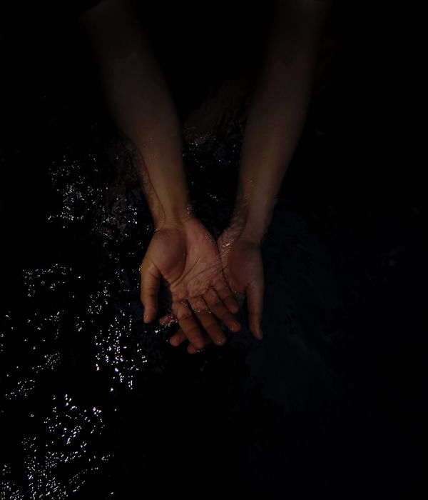 Person in a calm, fluid motion in a minimalist dark room with a red light accent.